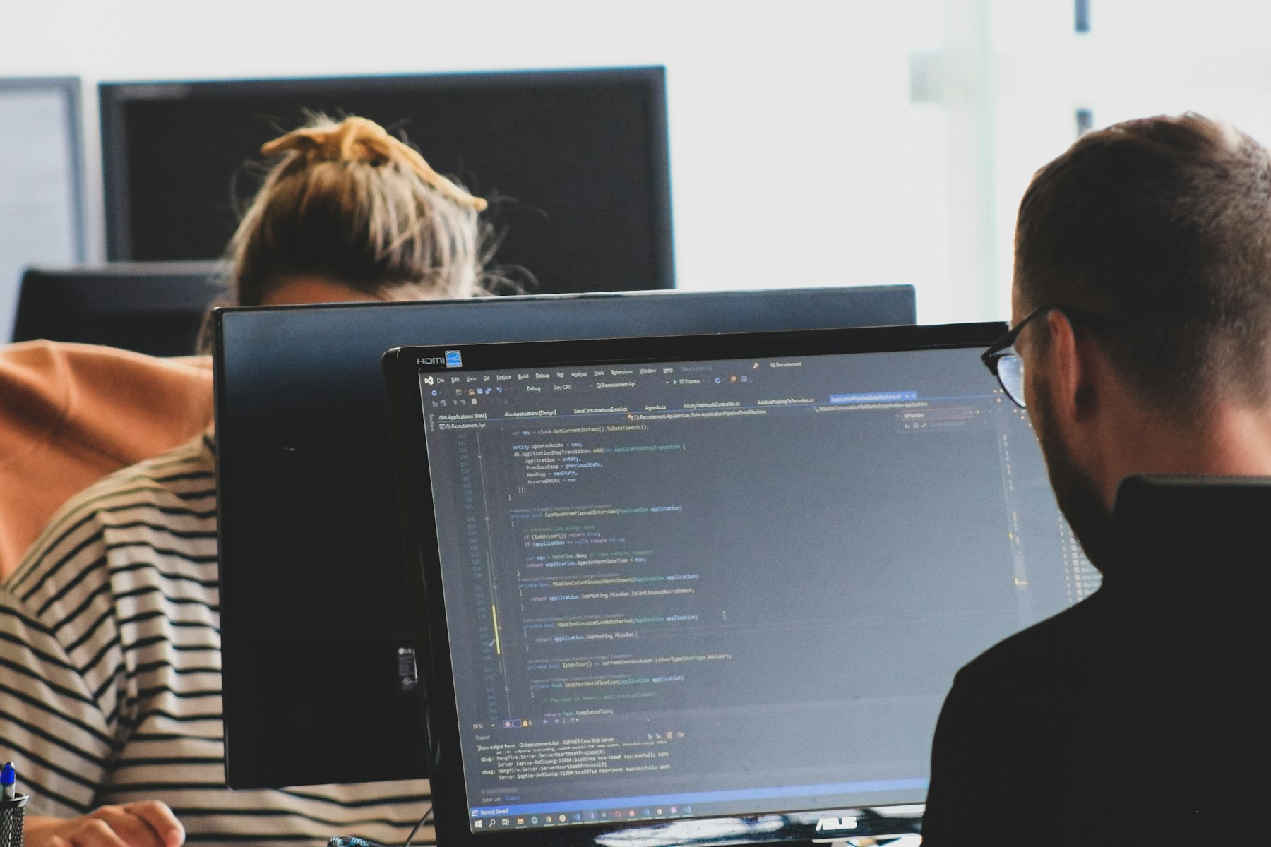 Two software researchers reviewing code at their workstations