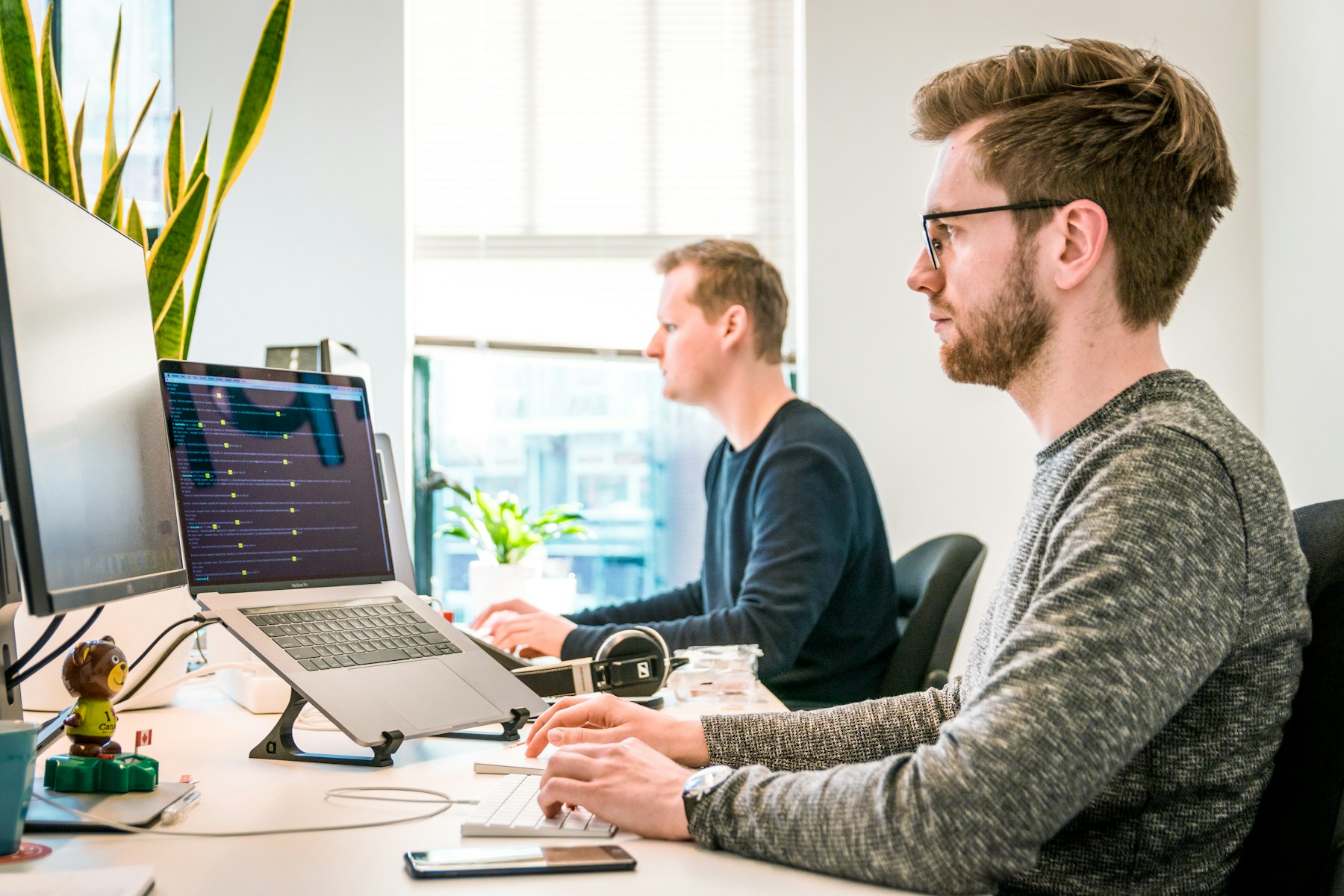 Two software engineers working at adjacent development stations