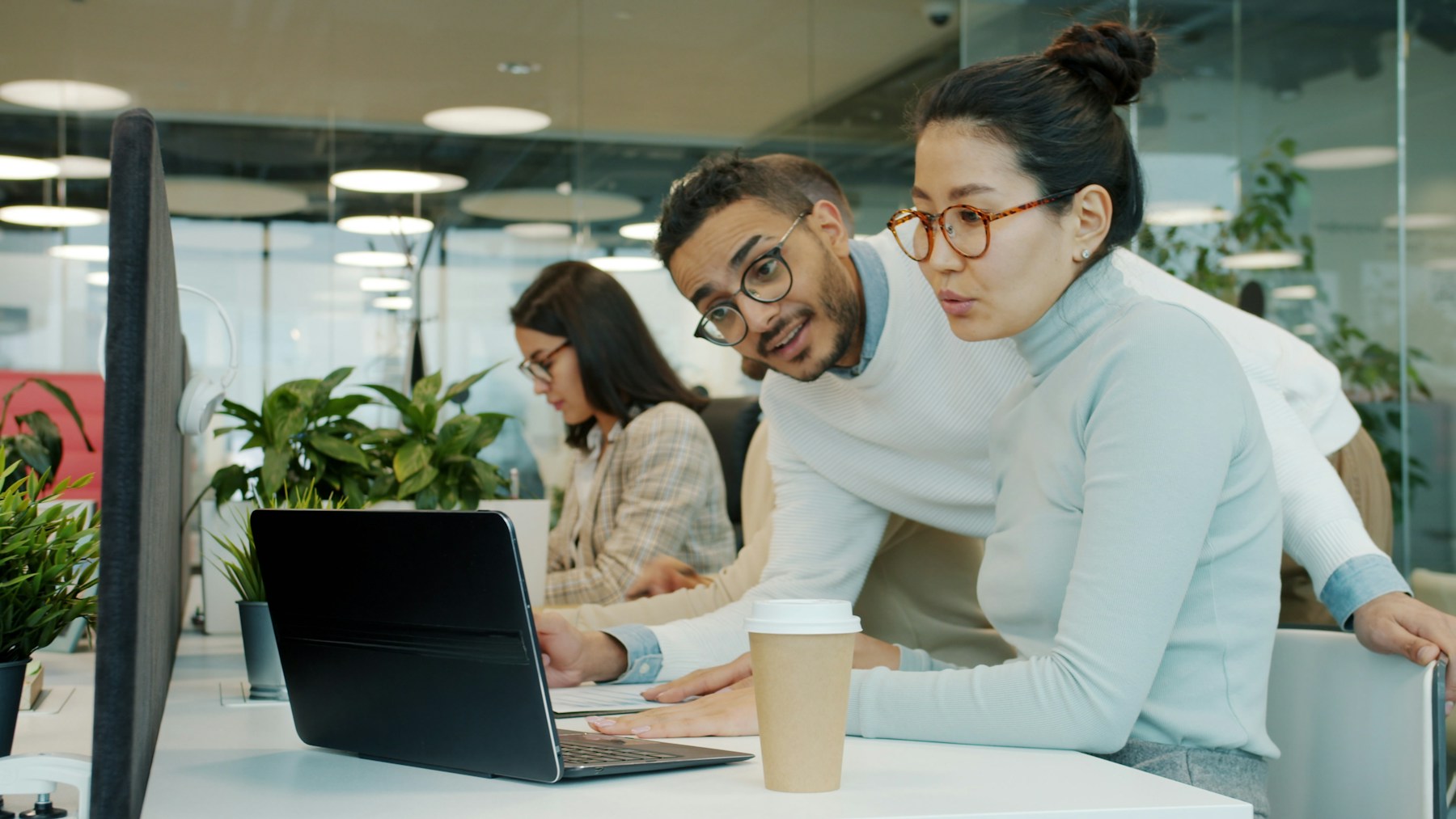 A professional team collaborating around a shared workstation